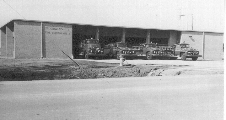 old fire trucks parked In front a fire station