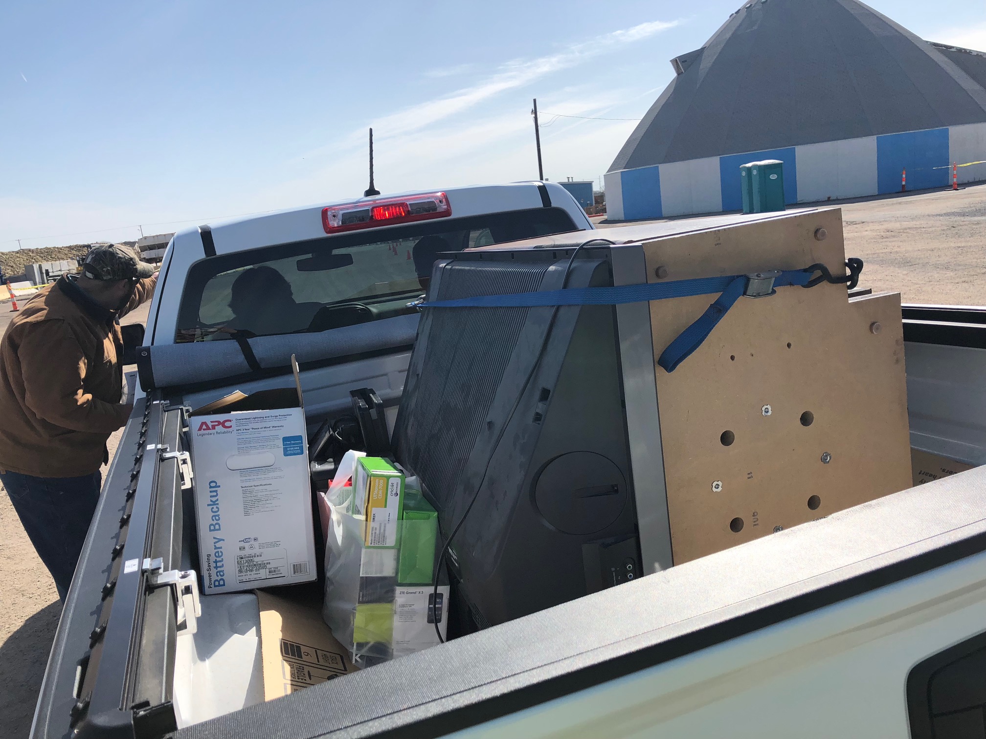a large television and other electronic waste in the bed of a truck