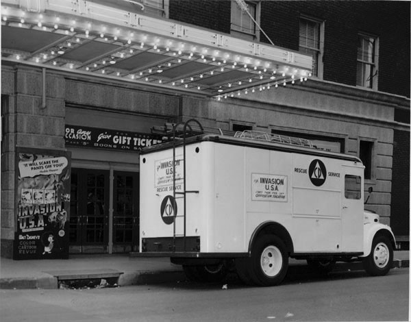 A 1940's Civil Defense Panel Truck in front of a storefront