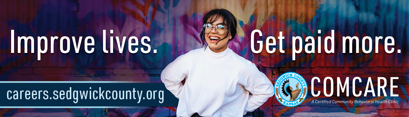 Women glasses hair wisping in face from wind in a white turtleneck smiling.